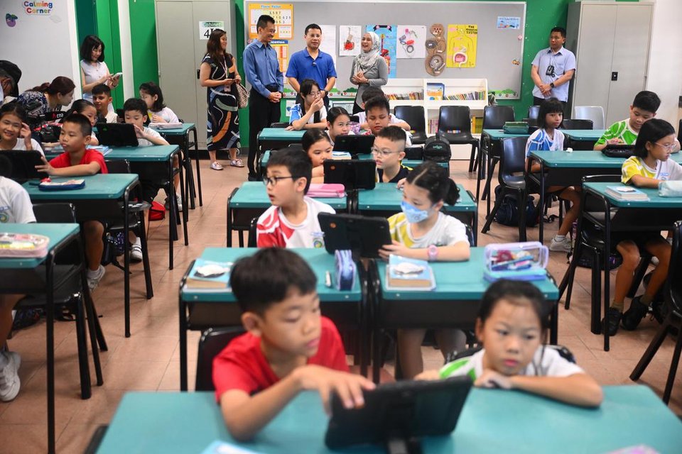 Mr Lee, accompanied by Oasis Primary School principal Danny Poh and Oasis Primary English head of department Munirah Eszham, during his first school visit in the role.  ST PHOTO: AZMI ATHNI