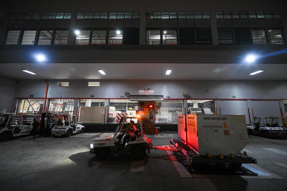 The handling of cargoes at one of Sats’ previous air freight terminals, in which loose cargoes had to be manually loaded onto a weighing scale and then moved into the warehouse for packing.  ST PHOTO: SHINTARO TAY